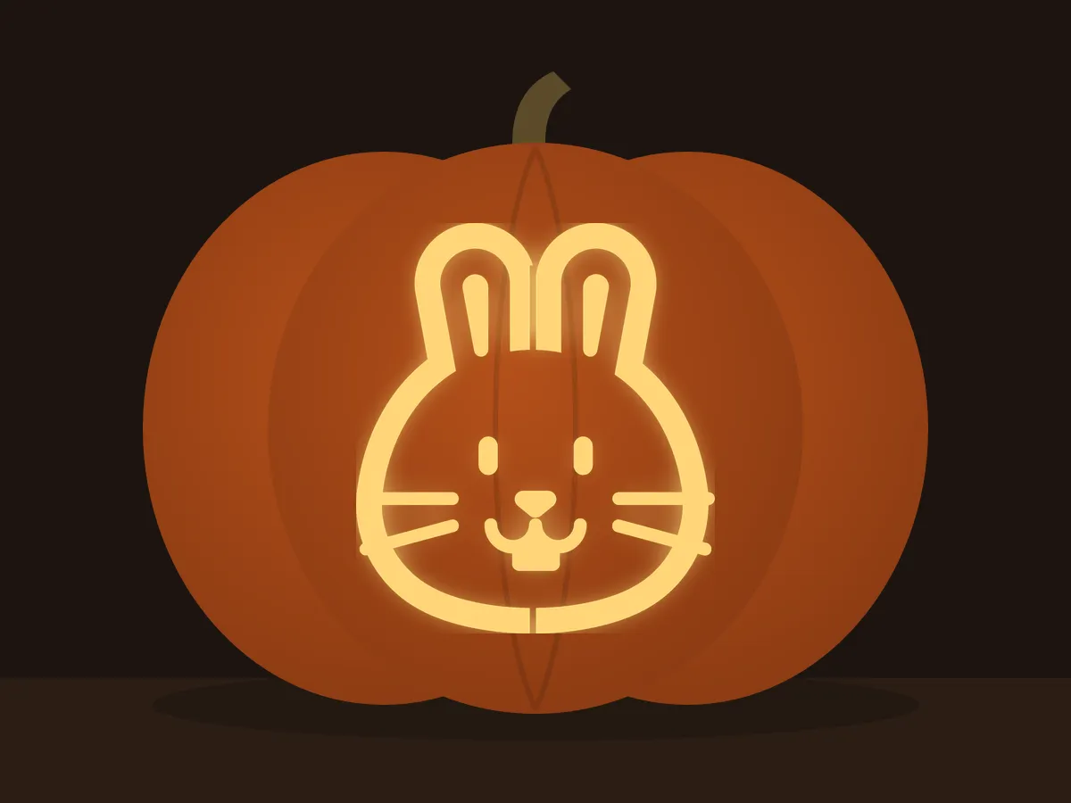 Carved pumpkin with the bunny face pattern, lit by a candle