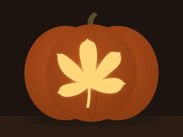 Carved pumpkin with the chestnut leaf pattern, lit by a candle