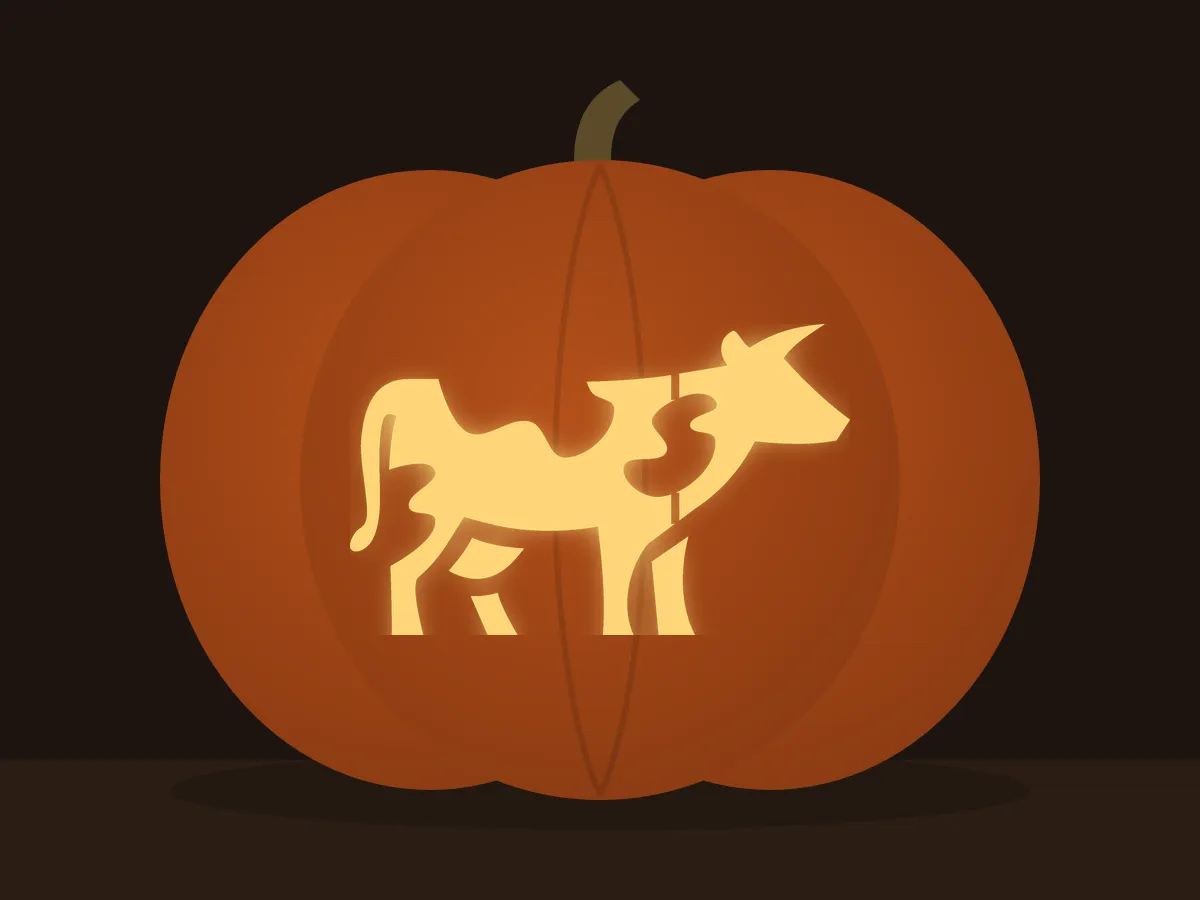 Carved pumpkin with the cow pattern, lit by a candle