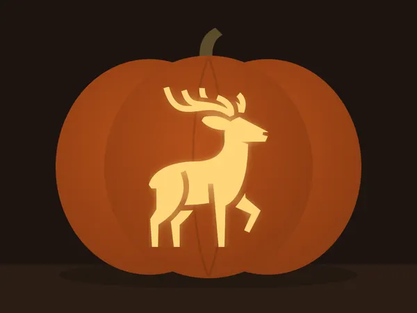Carved pumpkin with the deer pattern, lit by a candle
