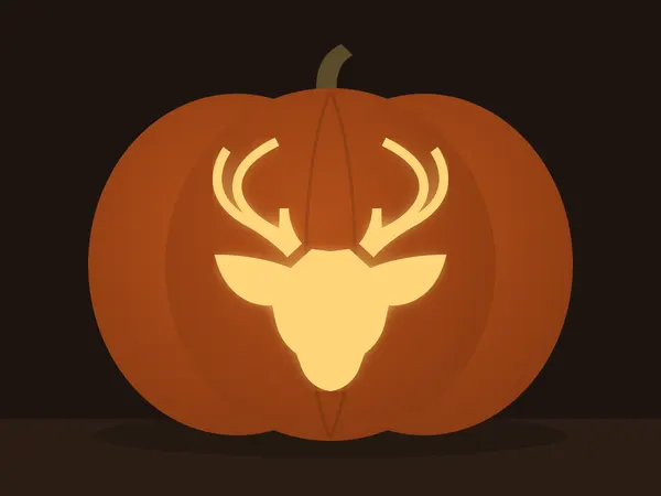 Carved pumpkin with the deer head pattern, lit by a candle