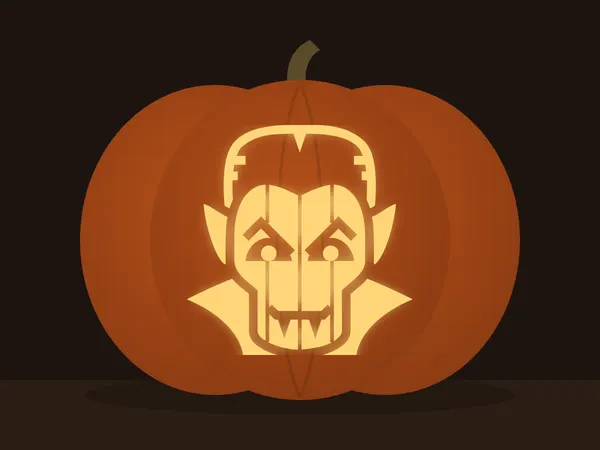 Carved pumpkin with the dracula pattern, lit by a candle