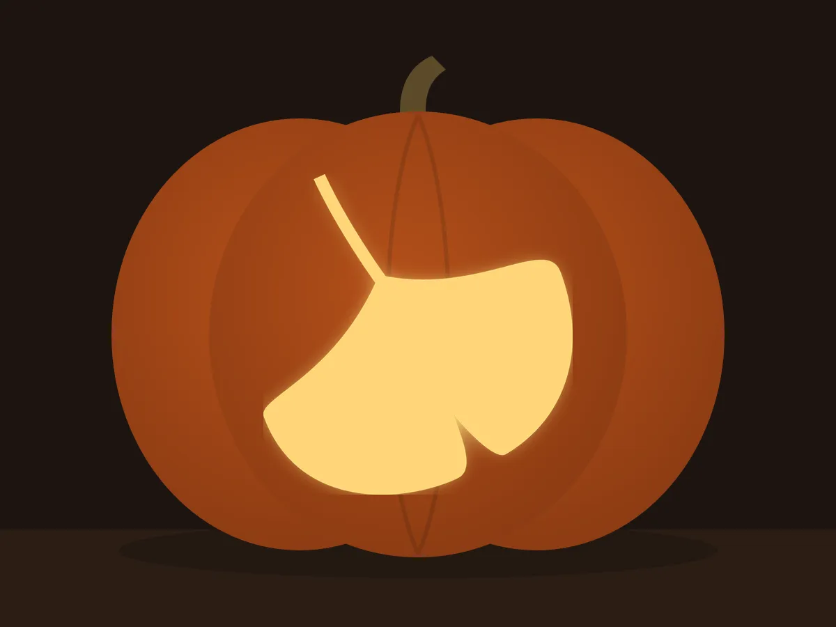 Carved pumpkin with the ginkgo leaf pattern, lit by a candle