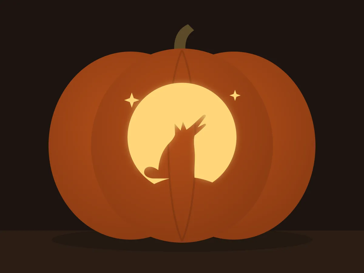 Carved pumpkin with the howling wolf pattern, lit by a candle