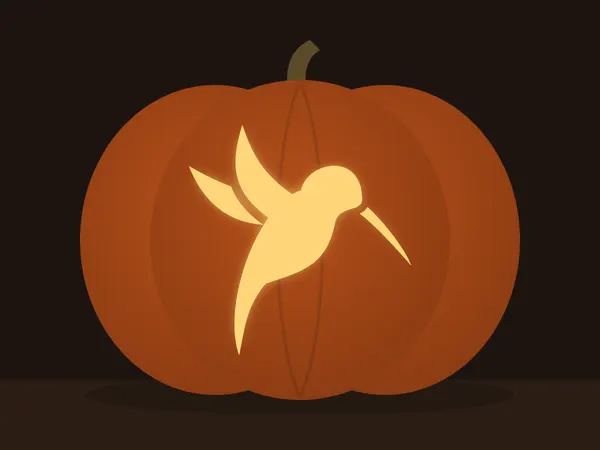 Carved pumpkin with the hummingbird pattern, lit by a candle