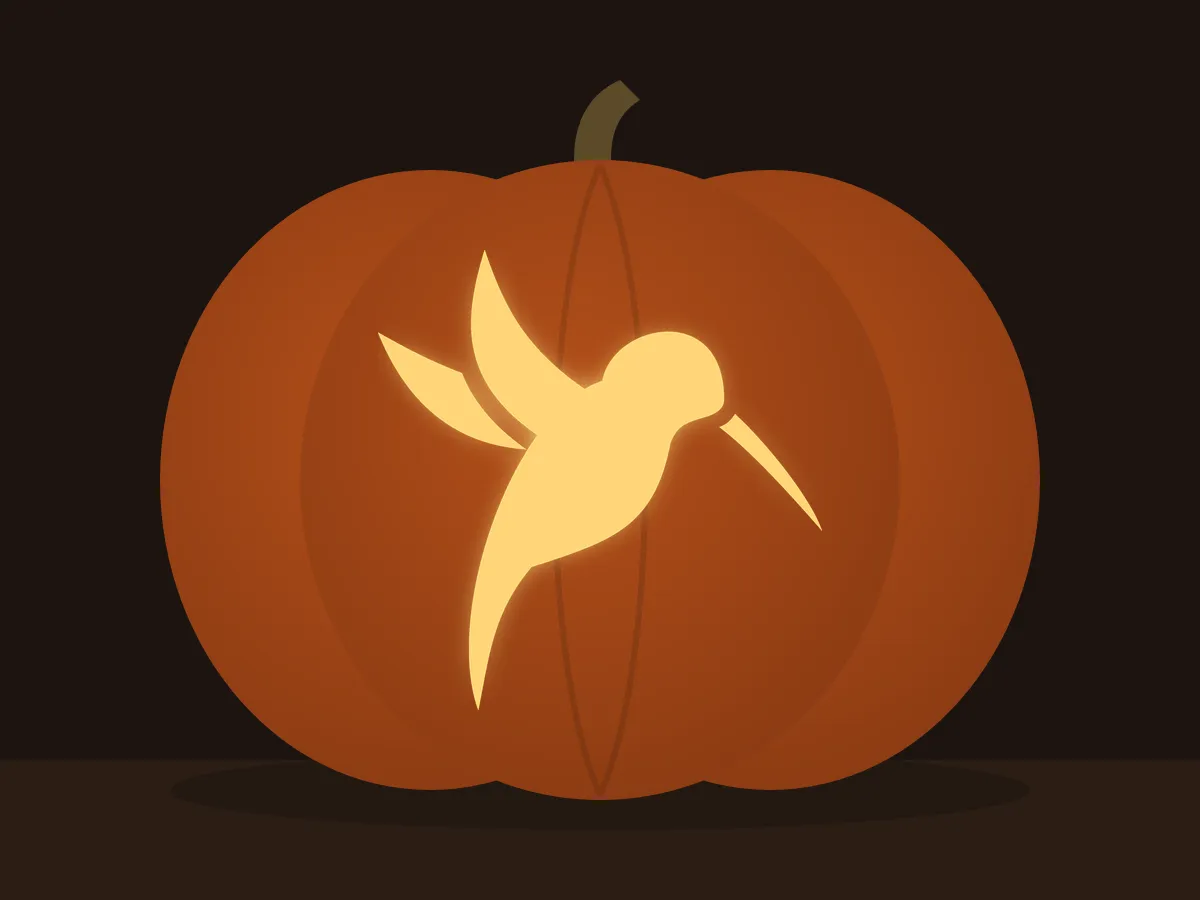 Carved pumpkin with the hummingbird pattern, lit by a candle