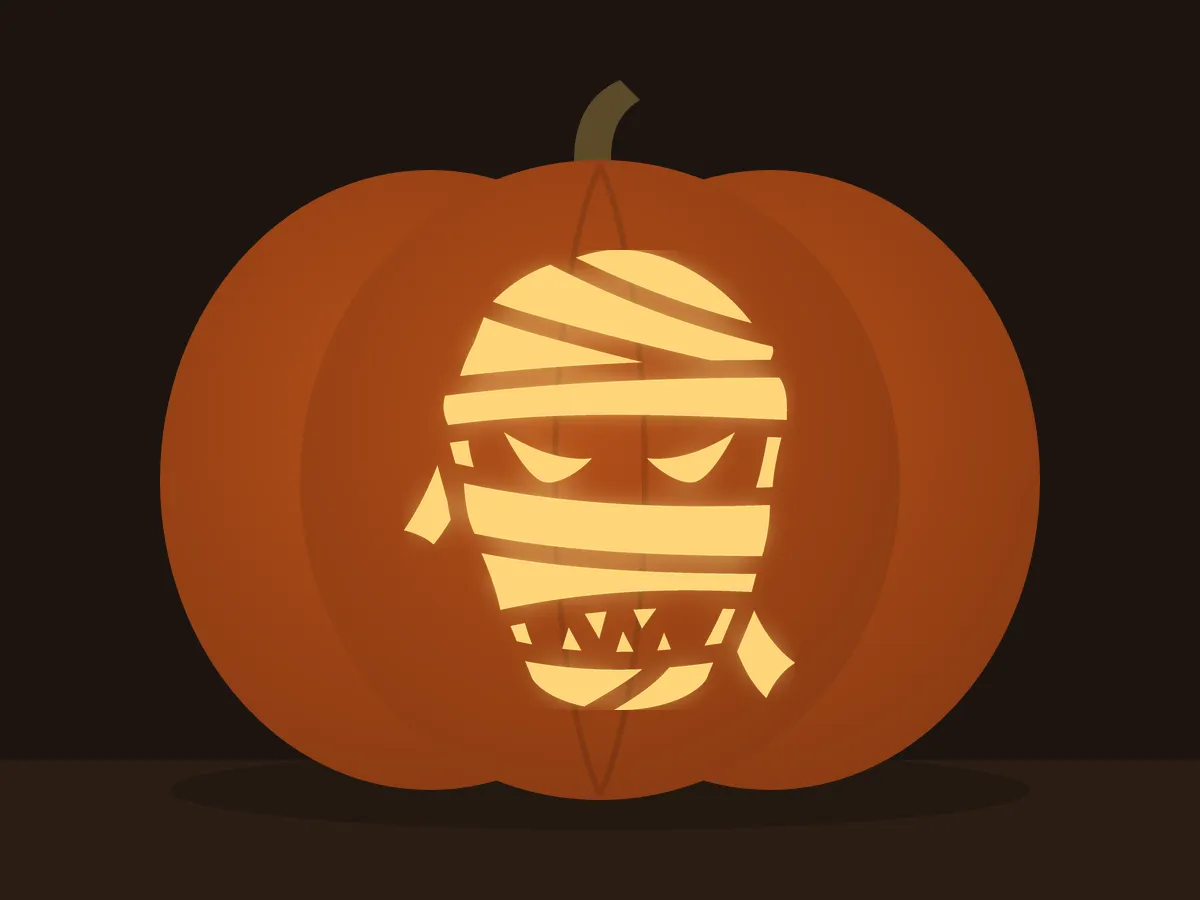 Carved pumpkin with the mummy face pattern, lit by a candle
