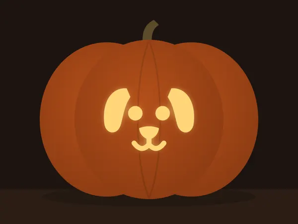 Carved pumpkin with the puppy face pattern, lit by a candle