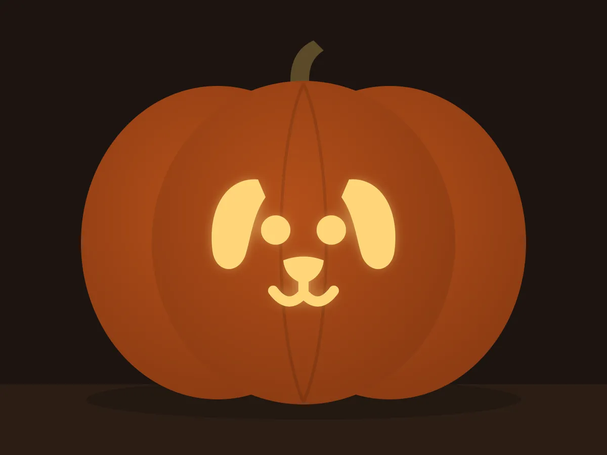 Carved pumpkin with the puppy face pattern, lit by a candle