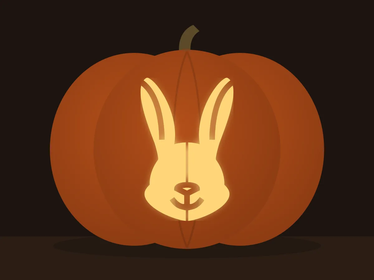 Carved pumpkin with the rabbit head pattern, lit by a candle
