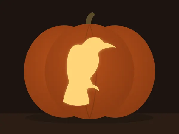 Carved pumpkin with the raven pattern, lit by a candle