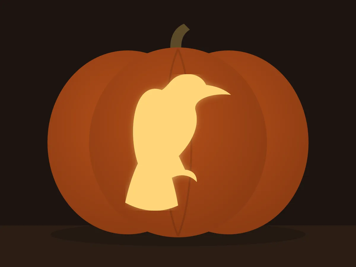 Carved pumpkin with the raven pattern, lit by a candle