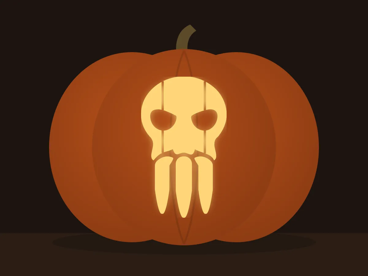 Carved pumpkin with the sabertooth skull pattern, lit by a candle