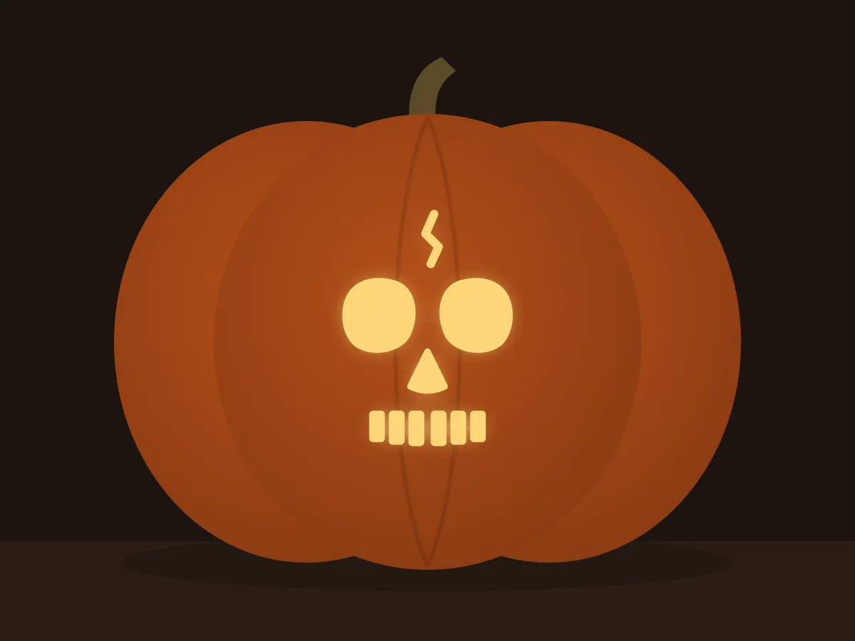 Carved pumpkin with the skull face pattern, lit by a candle