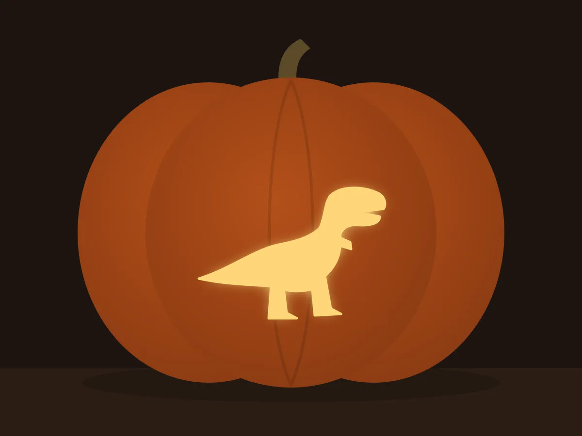 Carved pumpkin with the t-rex pattern, lit by a candle