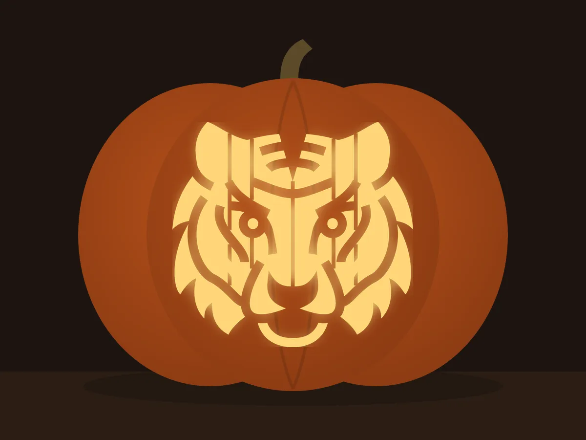 Carved pumpkin with the tiger head pattern, lit by a candle
