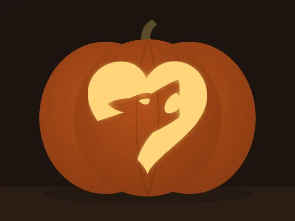 Carved pumpkin with the two wolves howling pattern, lit by a candle