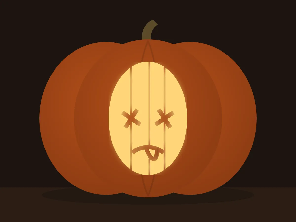 Carved pumpkin with the zombie head pattern, lit by a candle